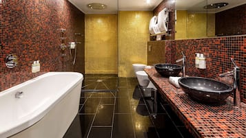 A modern bathroom with a freestanding bathtub, a large vessel sink, and a toilet.