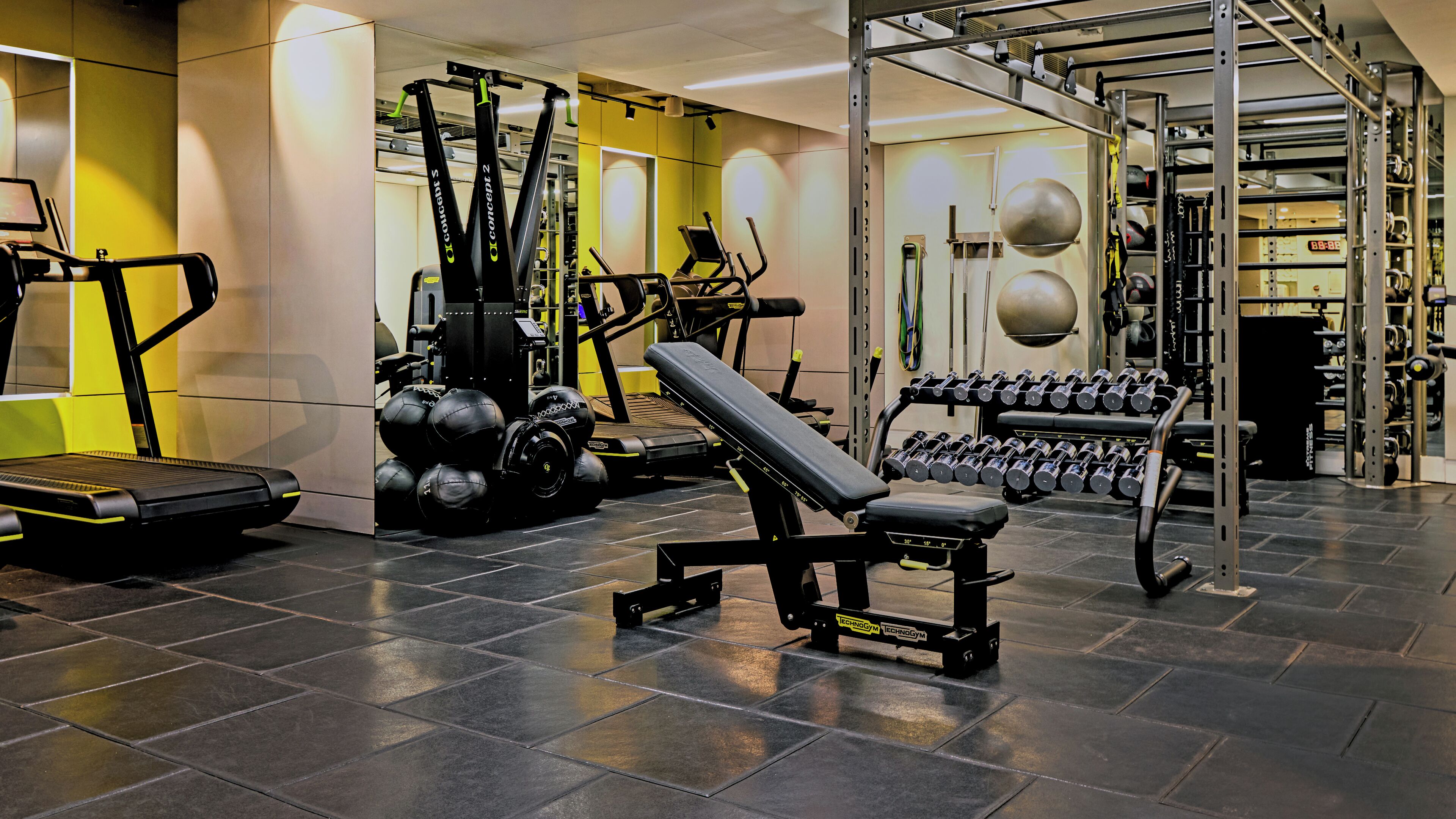A gym with various exercise equipment including treadmills, weight machines, and dumbbells.