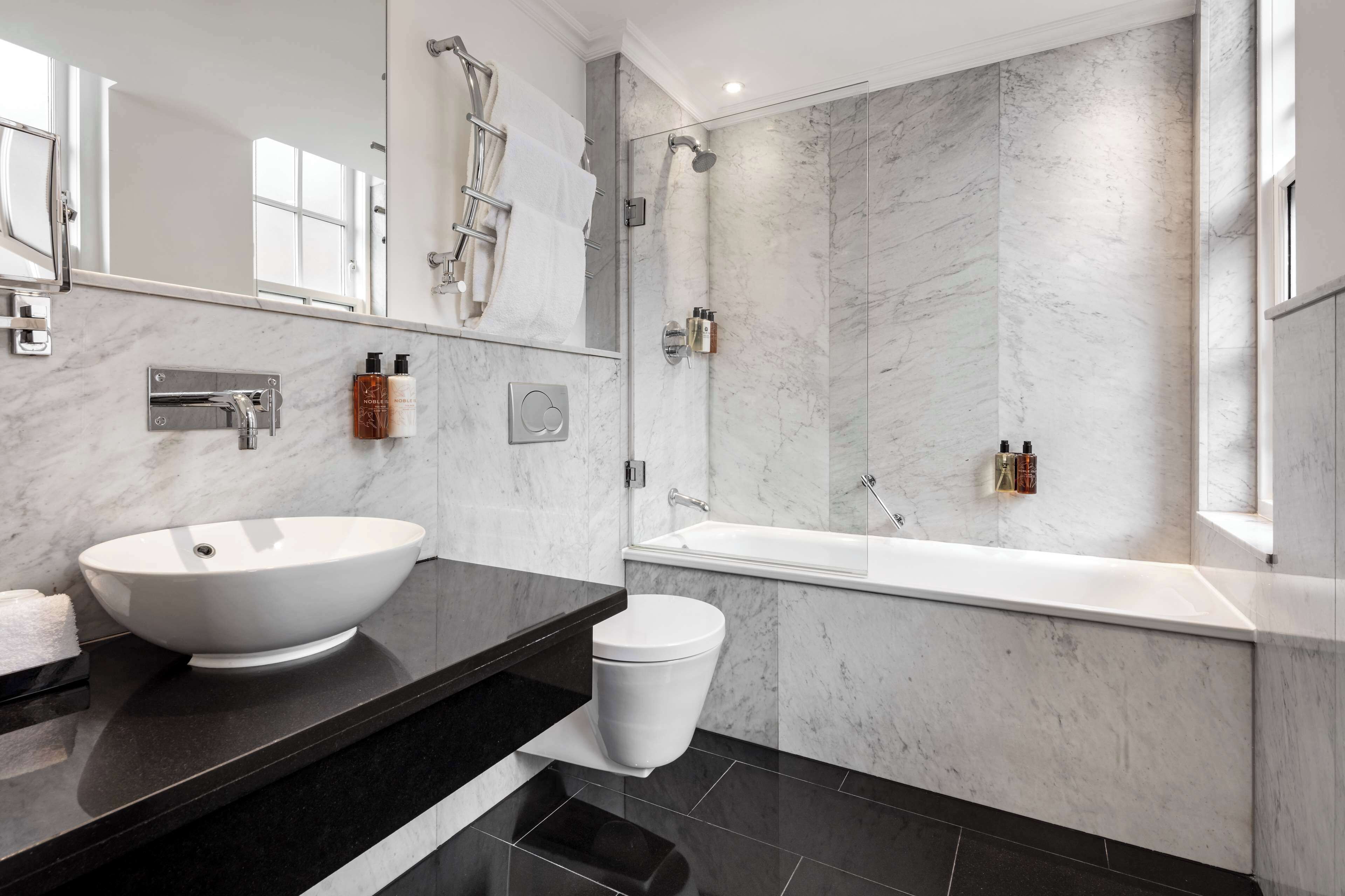 Une salle de bain moderne avec un grand lavabo blanc, une baignoire et une douche.