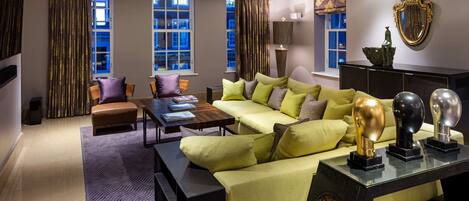 A modern living room with a yellow sofa, a wooden coffee table, and a patterned rug.