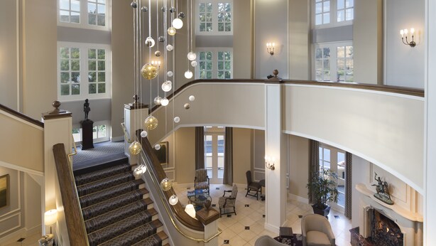 Un intérieur spacieux agrémenté d’un magnifique escalier, de plusieurs coins salon et de grandes fenêtres qui laissent entrer la lumière naturelle.