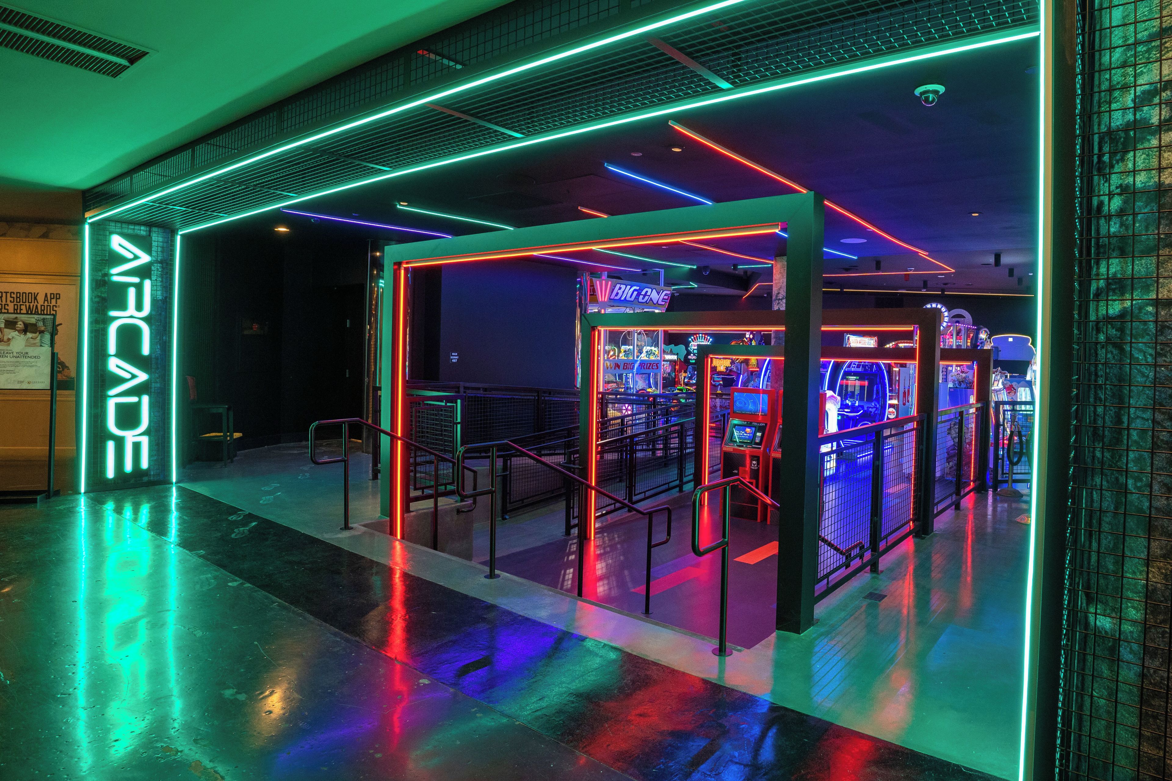 An arcade area with neon lights and gaming machines.