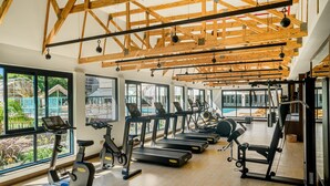 Et fitnesscenter med løbebånd, crosstrainere og styrkeudstyr.