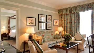 A living room with a sofa, armchairs, a coffee table, and framed artwork on the wall.