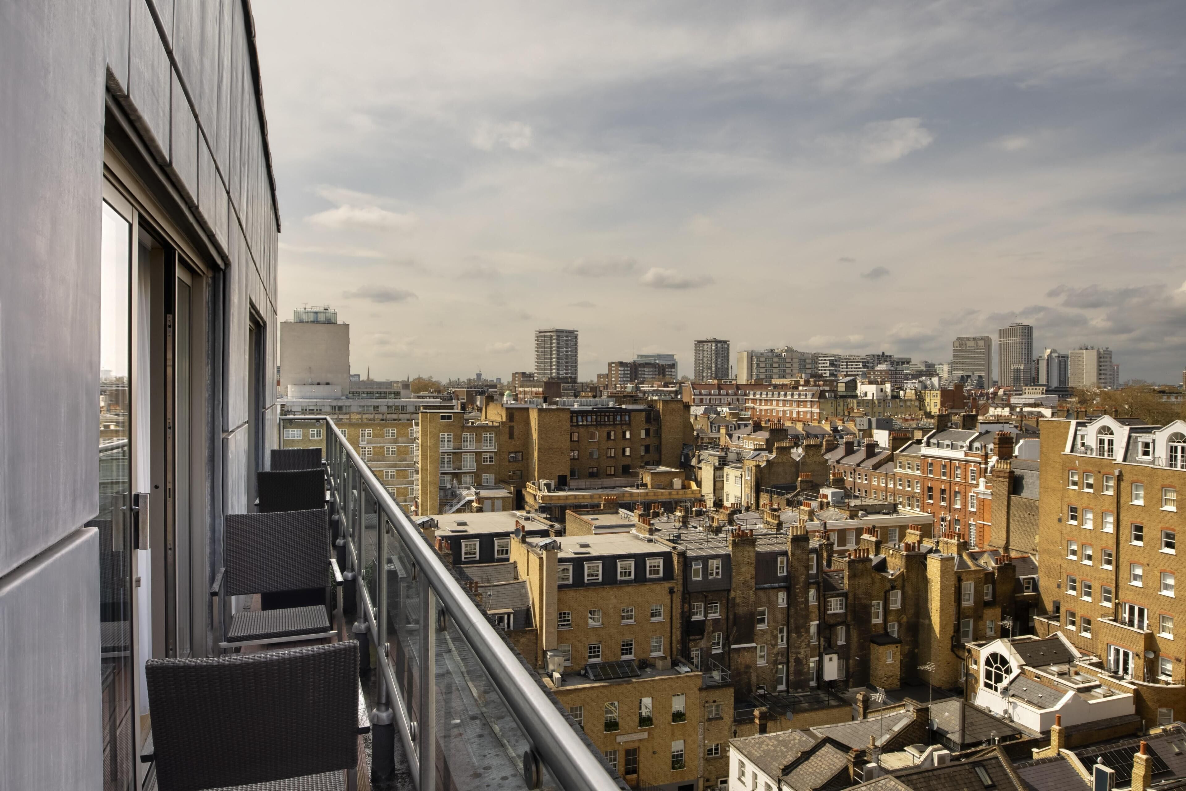 Un immeuble de grande hauteur offrant une vue sur une zone urbaine densément peuplée, avec un mélange de bâtiments résidentiels et commerciaux.