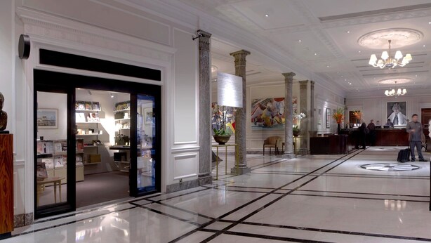 A spacious lobby with marble flooring, a reception desk, and a large chandelier. - Hyatt Regency London The Churchill (London)