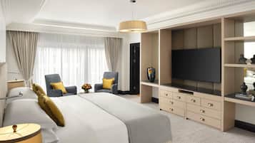 Habitación de hotel con una cama grande, televisión, escritorio y una silla.