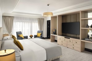 Habitación de hotel con una cama grande, televisión, escritorio y una silla.