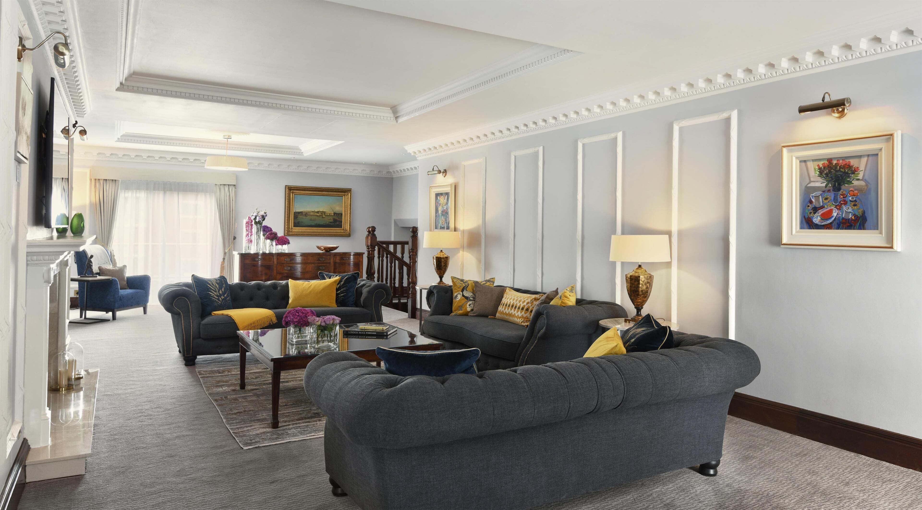 A spacious living room with a fireplace, multiple seating options, and a large window providing natural light.