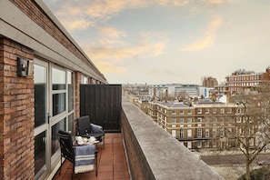 A balcony with a view of the cityscape, featuring brick buildings and a clear sky. - Hyatt Regency London The Churchill (London)