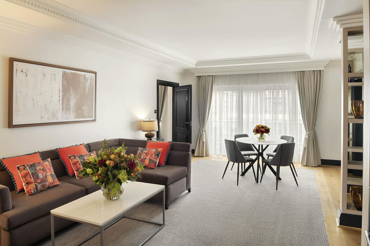 A modern living room with a sofa, coffee table, and dining area.