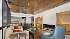 Una sala de estar moderna con un sofá, un sillón azul, una mesa de centro y una chimenea.