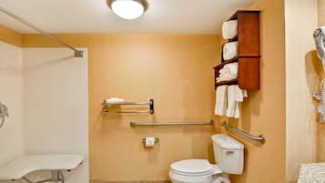 A bathroom with a shower, toilet, and a towel rack.