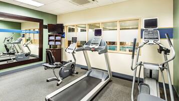A gym with treadmills, a stationary bike, and a rowing machine.