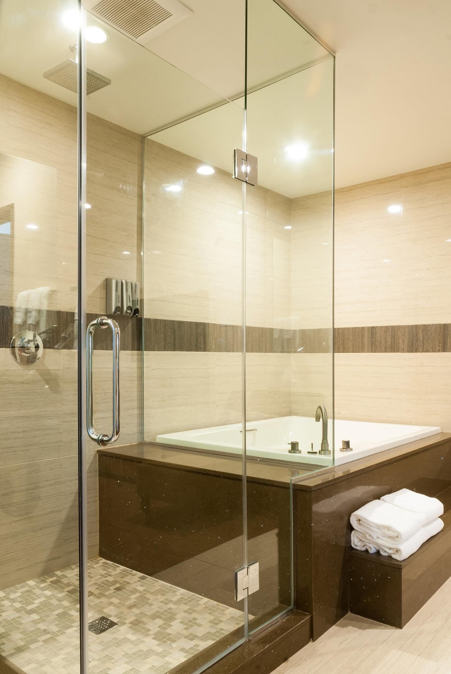 Un bagno moderno con cabina doccia in vetro, una vasca da bagno spaziosa e un portascopino.