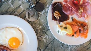 Two plates of food on a marble surface.