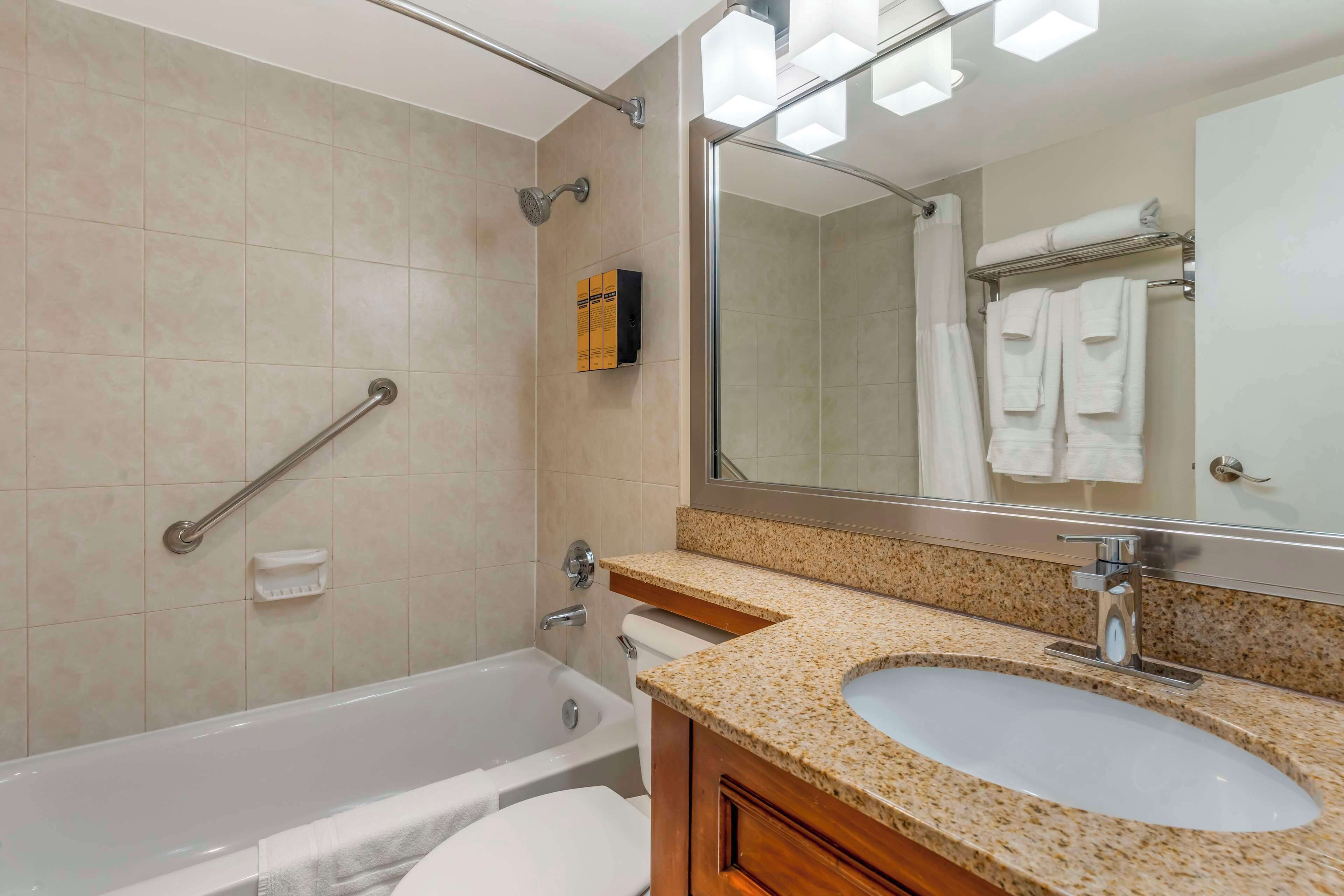 A modern bathroom with a bathtub, a sink, and a large mirror.