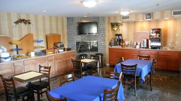 A restaurant with a bar area, seating for 10 people, and a kitchen with a TV.