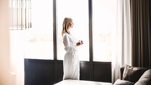 Ein Zimmer mit großem Fenster, einem Bett und einer Schlafcouch.