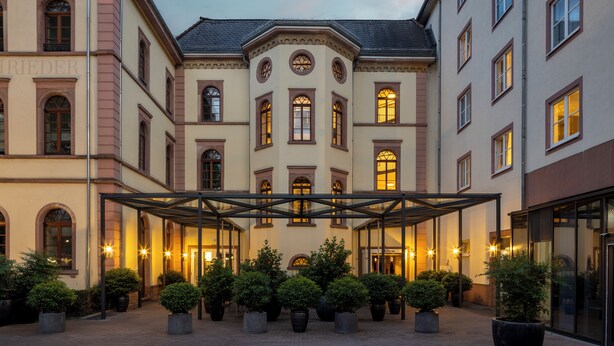 A hotel with a covered courtyard, multiple floors, and a classic architectural style. - Hilton Heidelberg (Heidelberg)