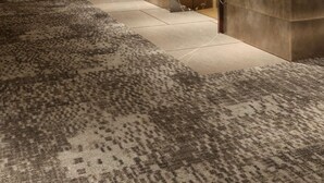 A hallway with a patterned carpet, recessed lighting, and elevator doors with a marble-like finish. - Hilton Heidelberg (Heidelberg)