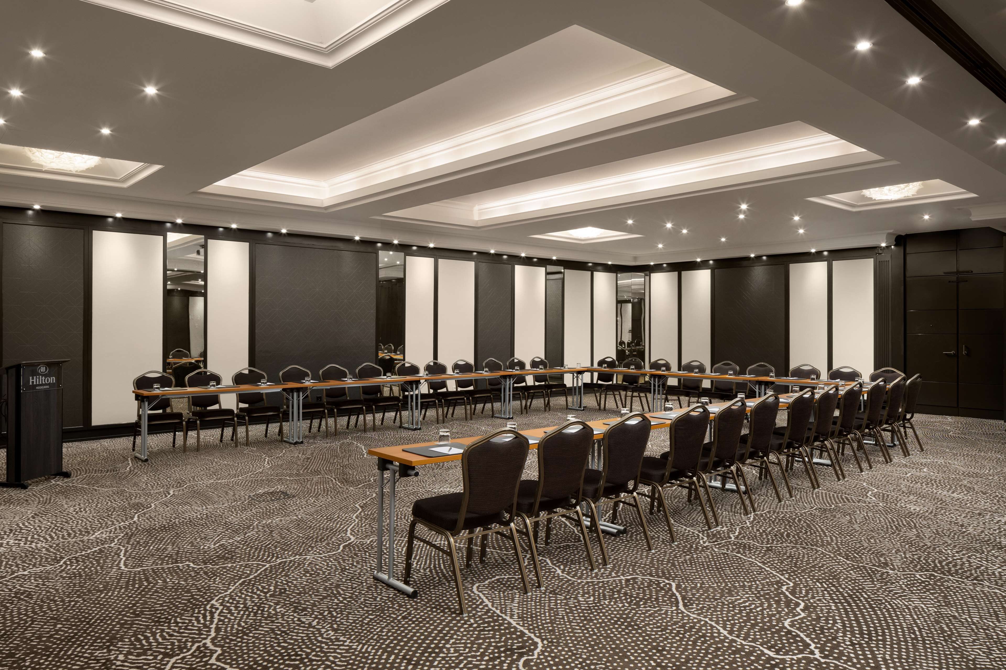 A conference room with a long table, chairs, and a podium.