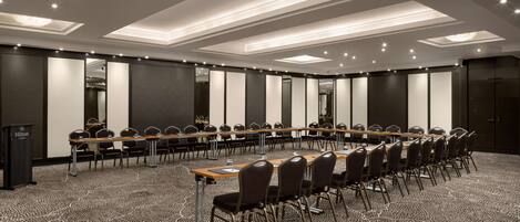 A conference room with a long table, chairs, and a podium.