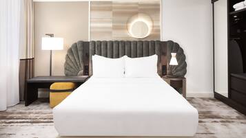 Ein modernes Hotelzimmer mit einem großen Bett, einem Nachttisch, einer Lampe und einem Spiegel an der Wand.