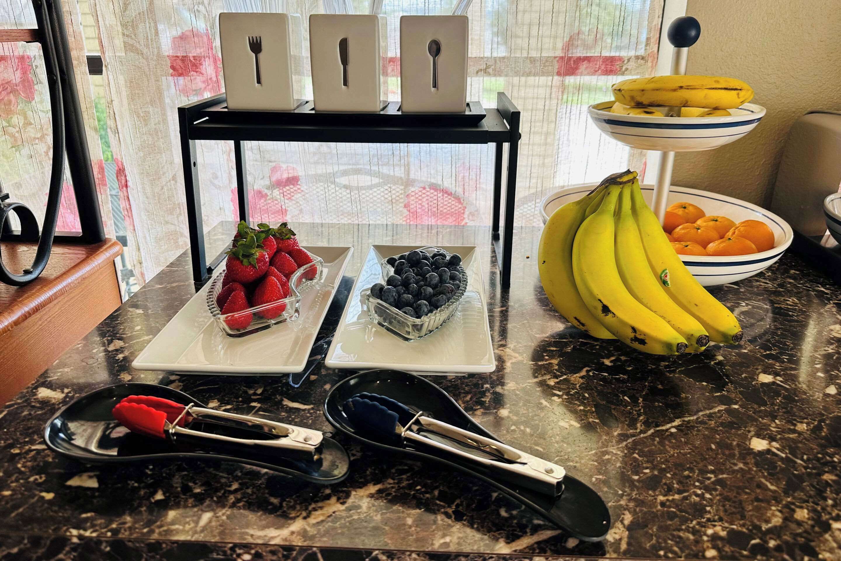 Een aanrecht met een presentatie van fruit, een satéprikker en een laptop.