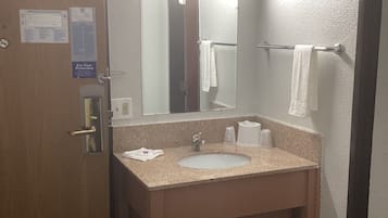 Et badeværelse på et hotel med håndvask, spejl, håndklædetørre og en dør med lås.