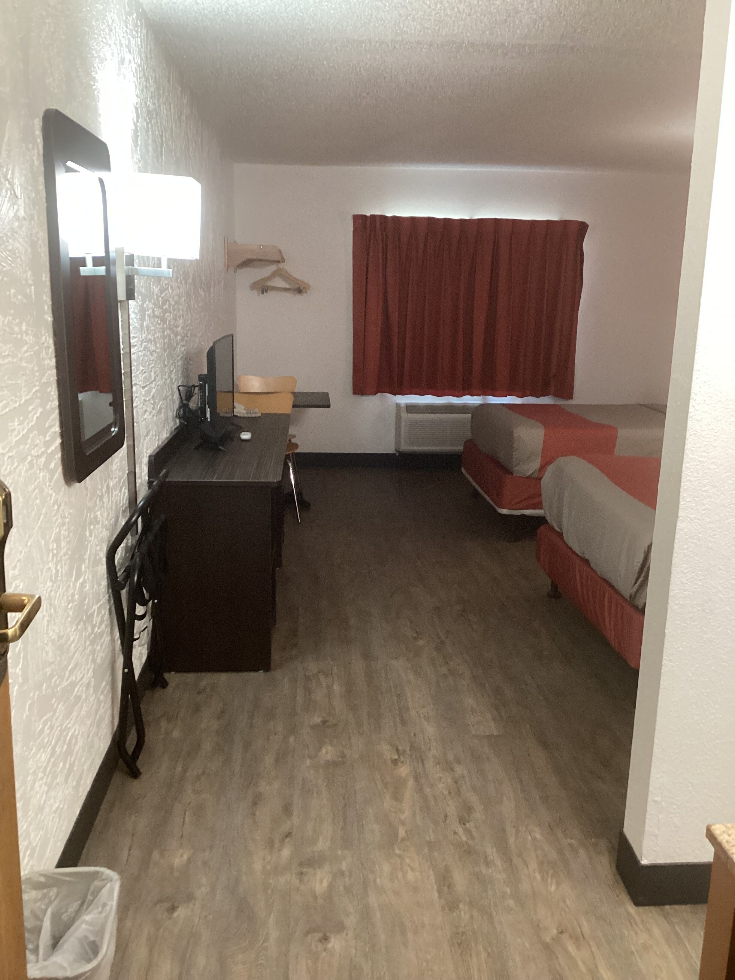 A compact room with a desk, chair, and a bed.