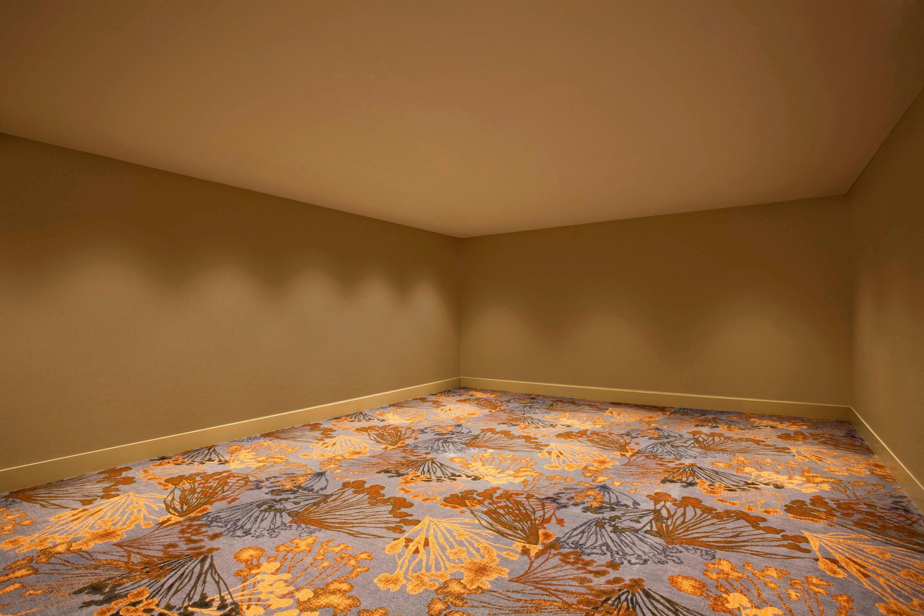Une pièce d’angle avec un tapis à motifs et des murs unis.