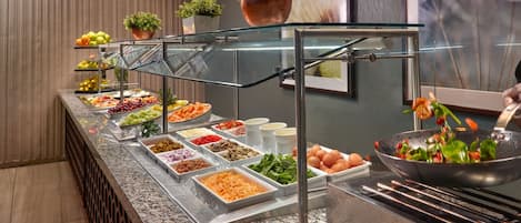 A buffet with various food items and a salad bar.