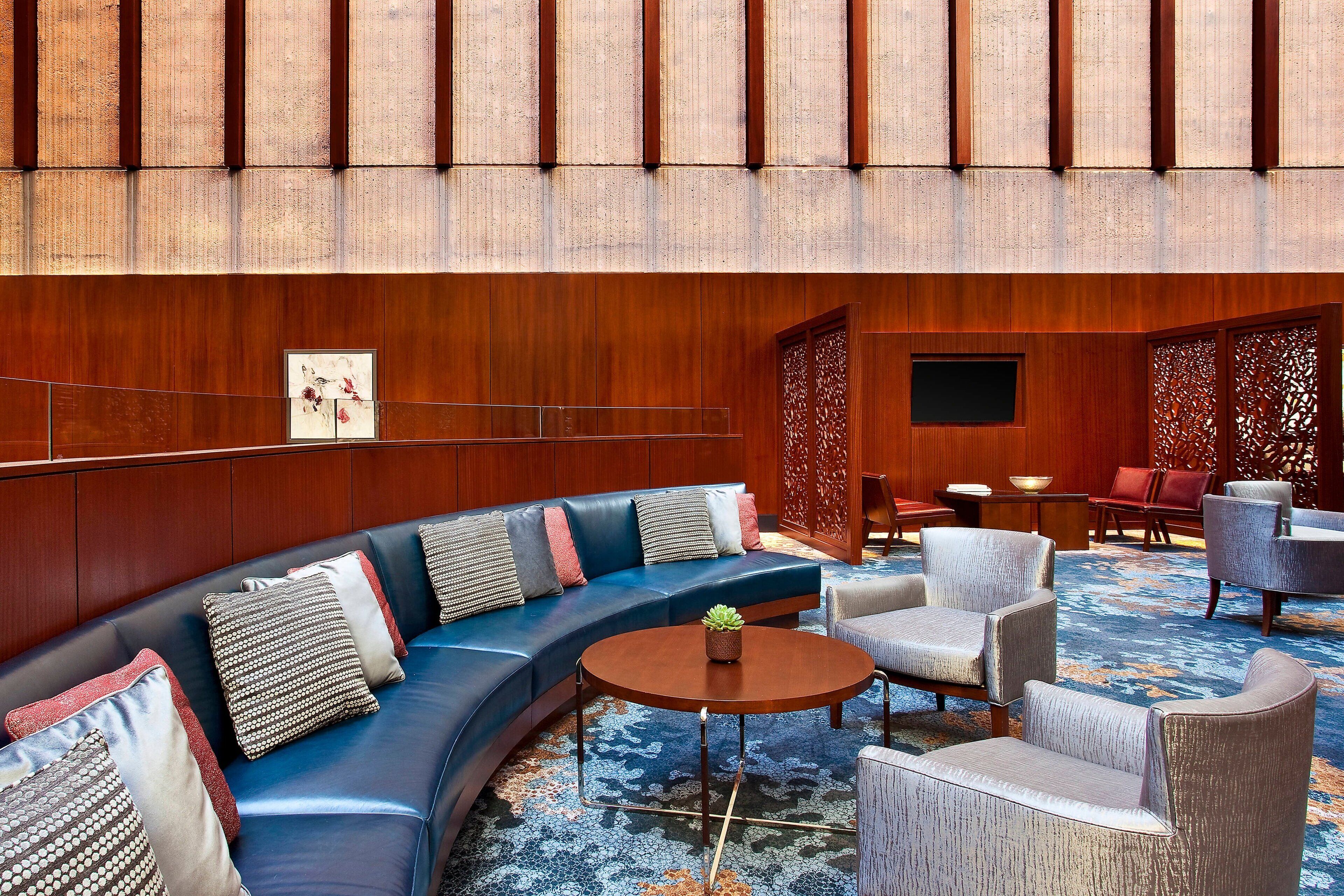 A modern lounge area with a curved sofa, armchairs, and a coffee table.