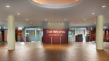 Um hall amplo com um destaque para a placa de entrada do The Westin Peachtree Plaza.
