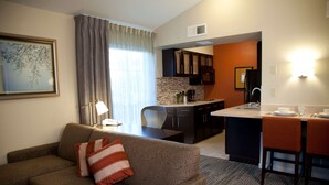Un espacio habitable compacto con sofá, mesa de comedor y kitchenette.