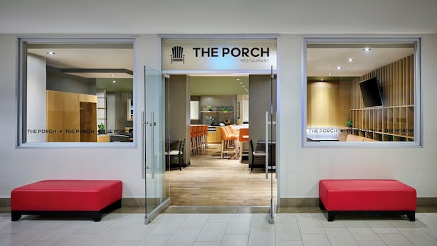 Un restaurante llamado “The Porch” con una decoración moderna, zona de estar y cocina a la vista.