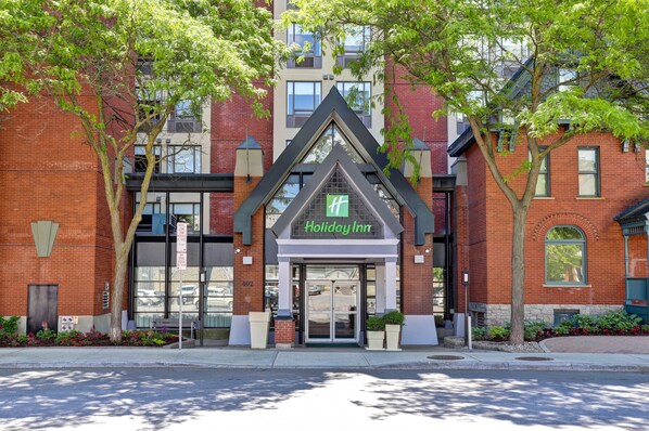 A Holiday Inn hotel with a brick facade, large glass entrance, and a prominent 'Holiday Inn' sign. - Holiday Inn Ottawa Dwtn - Parliament Hill by IHG (Ottawa)