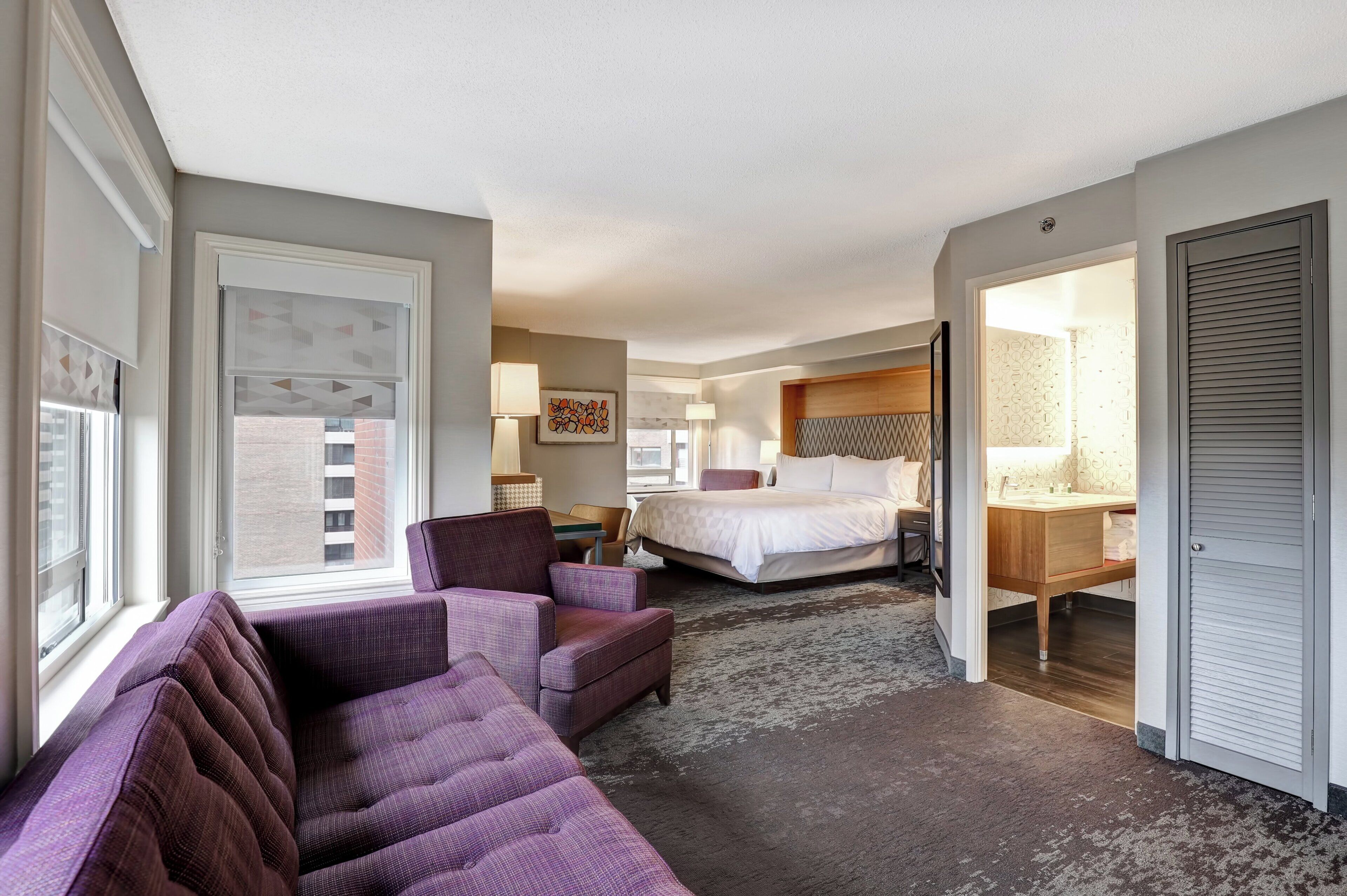 Une chambre d’hôtel avec un lit, un canapé, un bureau et une salle de bain.