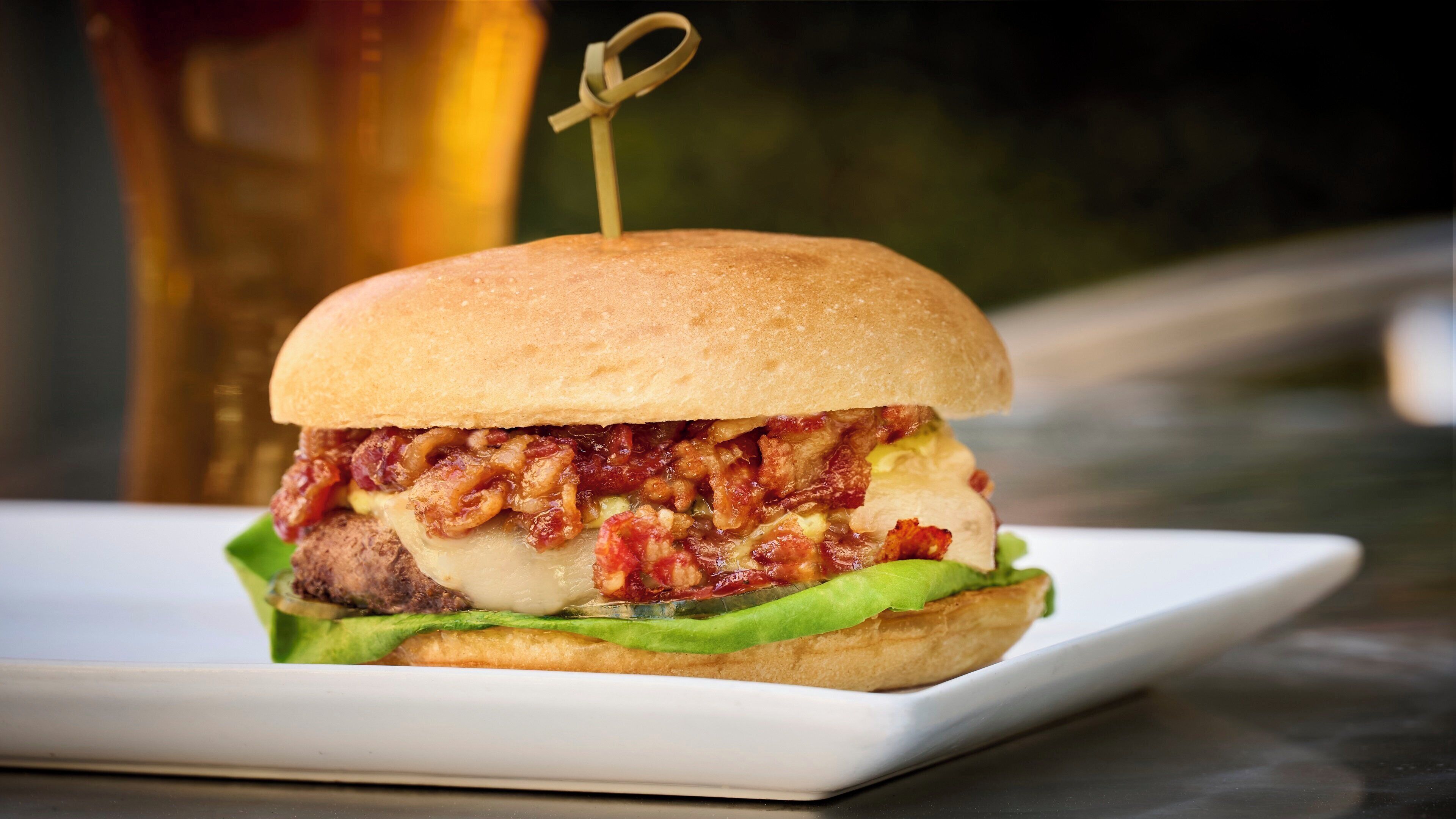 Un sandwich sur lequel on a planté un cure-dent, le tout posé sur une assiette blanche.