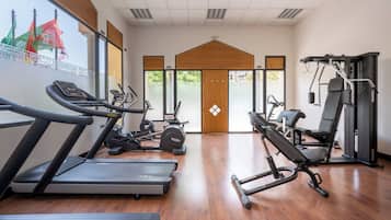 Une salle de sport équipée de tapis de course, de vélos elliptiques et de matériel de musculation.