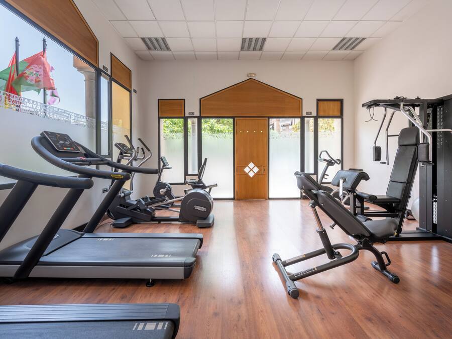 Une salle de sport équipée de tapis de course, de vélos elliptiques et de matériel de musculation.