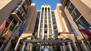 A hotel with a modern architectural design, featuring a prominent entrance with columns and a large sign at the top.