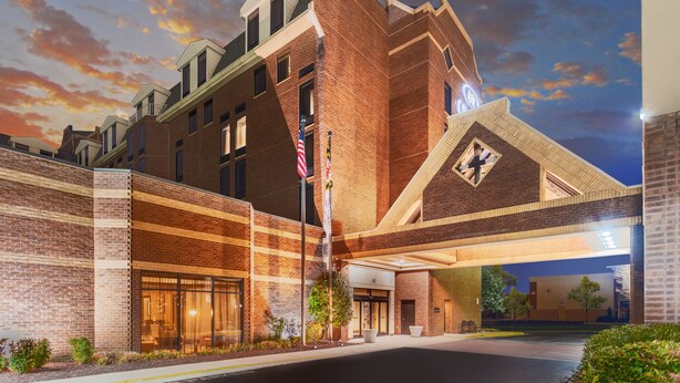 A multi-story hotel with a brick facade, large windows, and an American flag. - Crowne Plaza Annapolis by IHG (Annapolis)