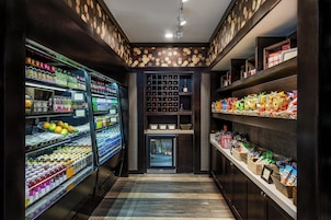 A well-lit snack and beverage kiosk with a variety of snacks and drinks, including bottled water, juices, and snacks.