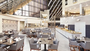 A spacious hotel lobby with multiple dining areas, a central bar, and a high ceiling with exposed beams. - DoubleTree by Hilton Dallas Near the Galleria (Dallas)