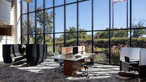 A modern office space with large windows, a desk with a computer, and black office chairs. - Sonesta San Jose - Milpitas (Milpitas)