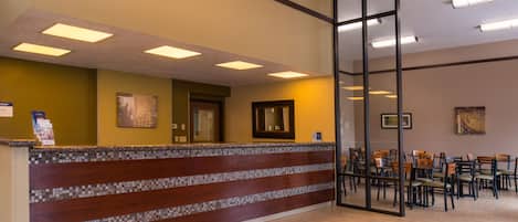 A reception area with a counter, chairs, and an exit sign.