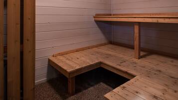 A corner of a room with wooden flooring and a bench.