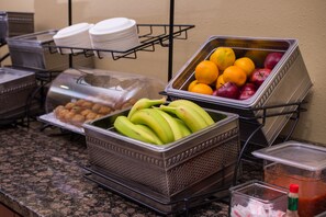 A buffet with various food items including fruits and nuts.